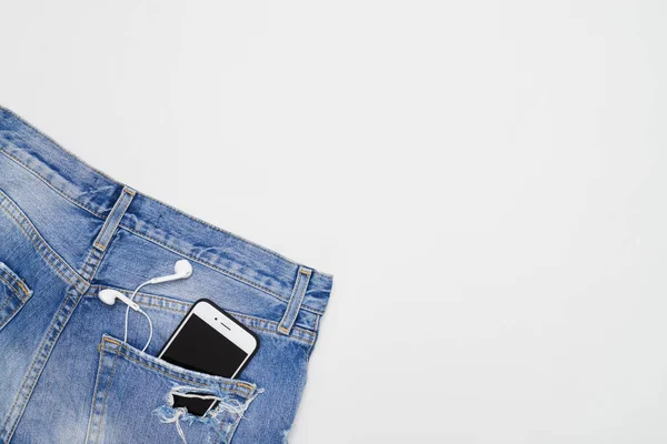 Foto flat lay di pantaloncini con telefono e cuffie in pock — Foto Stock