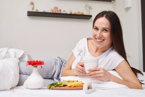 Charmante fille couchée au lit a son petit déjeuner romantique — Photo