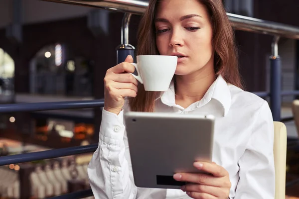 Mujer de negocios disfrutando de una taza de café y leyendo noticias en la tableta —  Fotos de Stock