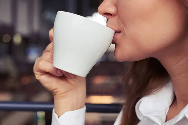 Großartiges mageres Mädchen im weißen Hemd genießt eine Tasse Kaffee — Stockfoto