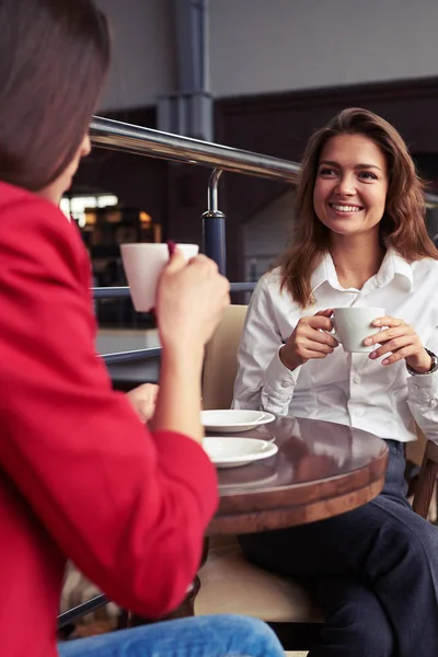 Twee prachtige vrouwelijke drinken koffie en genieten van gesprek — Stockfoto
