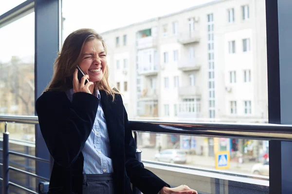 Vrouw kreuken neus en lachen tijdens het gesprek op de telefoon — Stockfoto