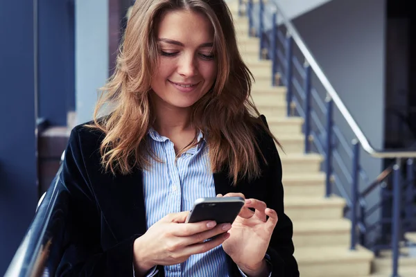 Brunett tjej beter sin smartphone — Stockfoto