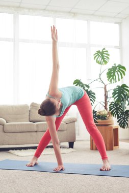 Güzel kadın Yoga egzersiz yoga dostum oturma odasında yapmak