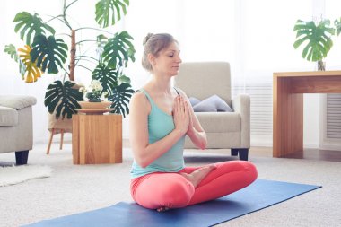 Güzel sporcumuz Yoga mat üzerinde otururken meditasyon