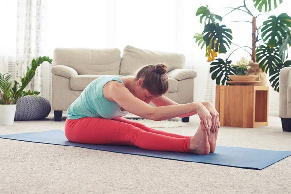 Hermoso castaño practicando yoga en inclinación sentada hacia adelante — Foto de Stock