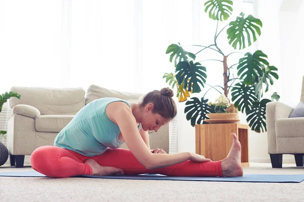 Glorious girl practicing yoga in head-to-knee yoga pose — Stock Photo, Image