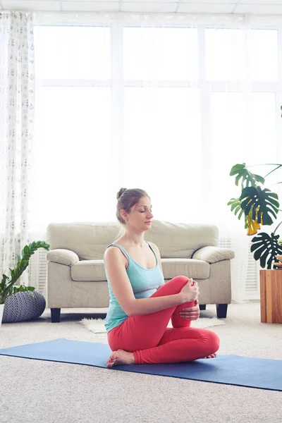 Woman in fashionable tights doing yoga fish pose on yoga mat — Stock Photo, Image