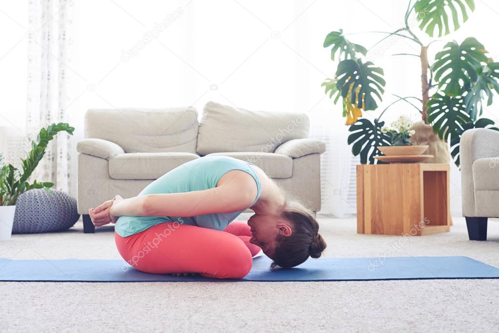 Gorgeous female practicing seated bound lotus posture