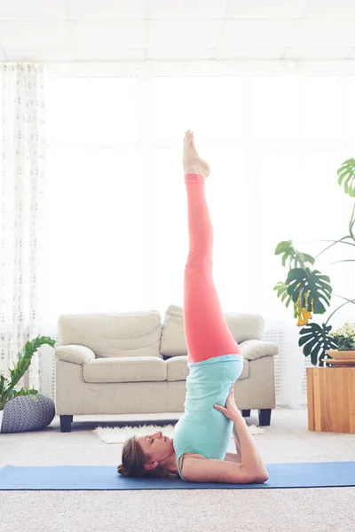 Mujer maravillosa practicando yoga mientras está de pie sobre los hombros — Foto de Stock