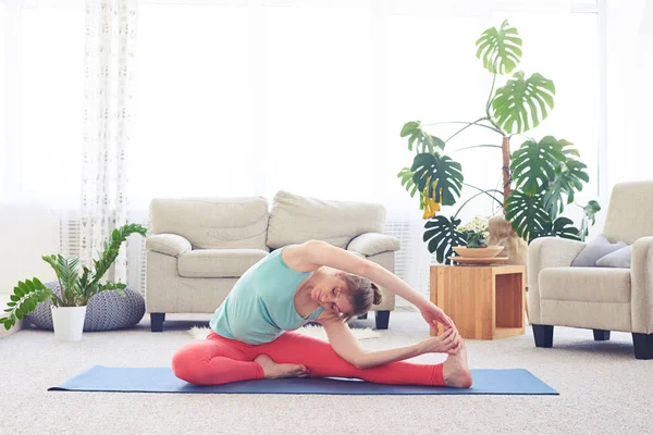 Fantastic girl stretching in revolved head-to-knee pose — Stock Photo, Image