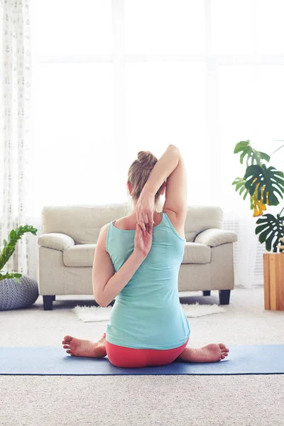 Avslappnad kvinna mediterar med händer i lås bakom rygg — Stockfoto