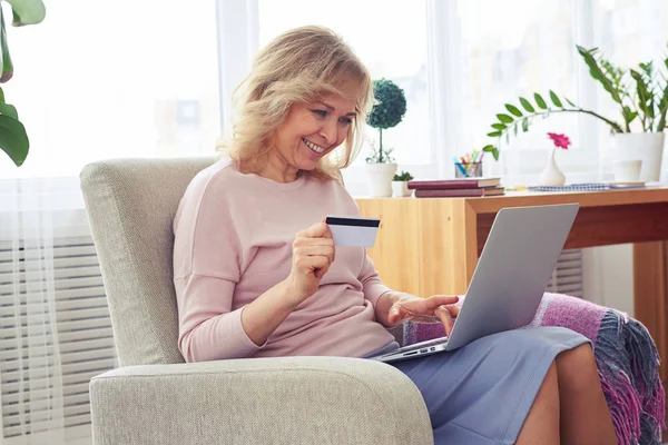 Marvelous female entering number of credit card while working in — Stock Photo, Image