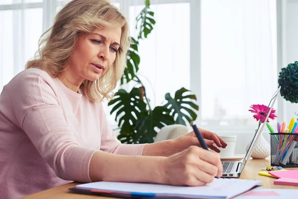 Merveilleuse écriture féminine tout en travaillant dans un ordinateur portable — Photo