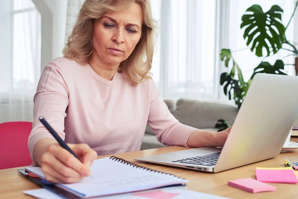 Vrouw schrijven terwijl u werkt in de laptop — Stockfoto