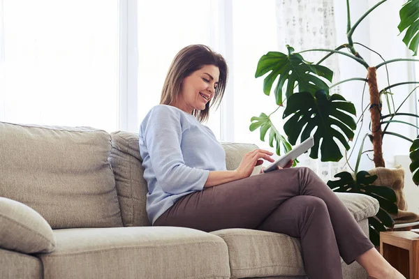 Aantrekkelijke vrouw die werkt in laptop zittend op de Bank — Stockfoto