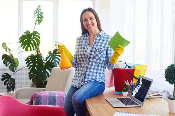 Good-looking lady sitting on table and holding mop and splash — Stock Photo, Image
