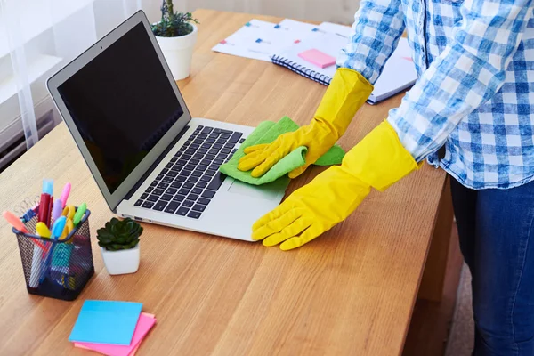 Femme au foyer en gants époussetant ordinateur portable — Photo