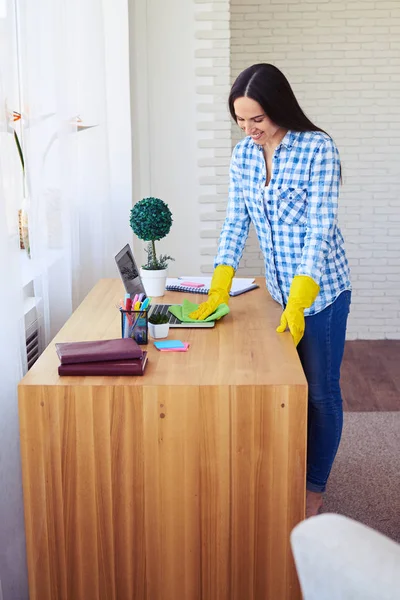 Attractive female dusting laptop standing on table — Stock Photo, Image