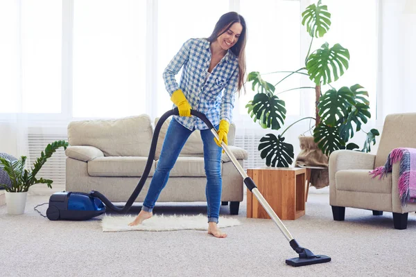 Slim woman cleaning with vacuum cleaner carpet — Stock Photo, Image