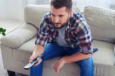Acımasız adam dikkatle izliyor ve uzak ile kanal değiştirme