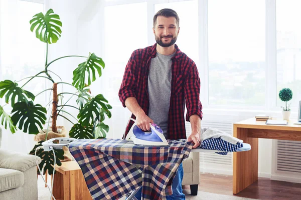 Skäggiga manliga stryka kläder ombord — Stockfoto