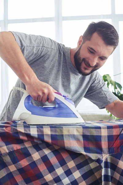 Caring man ironing diligently shirt on board — Stock Photo, Image