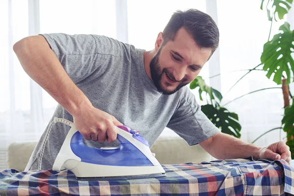 Stylish brunet ironing diligently shirt on board — Stock Photo, Image