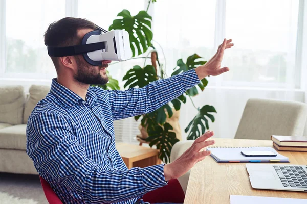 Bärtiger Herr in Virtual-Reality-Brille bei der Arbeit im Sitzen — Stockfoto