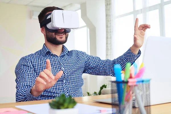 Dark haired male in virtual reality goggles while sitting at tab — Stock Photo, Image