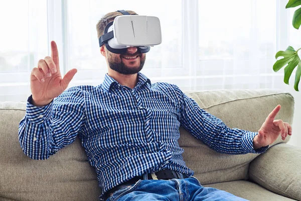 Smiling male in blue shirt working in virtual reality glasses si — Stock Photo, Image