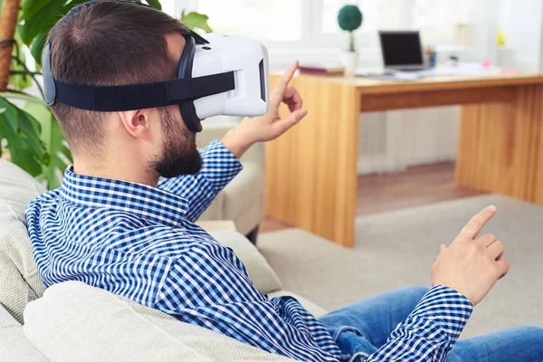 Handsome mister with beard working in VR glasses sitting on sofa — Stock Photo, Image