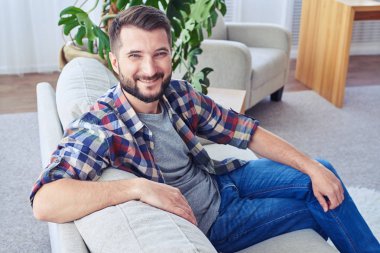 Moda kanepede rahatlatıcı mavi gözlü yakışıklı erkek