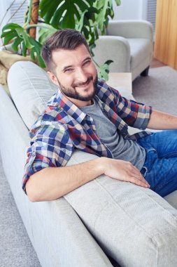 Beyefendi arkasına yaslanmış Kareli gömlekli hoş bir gülümseme ile 