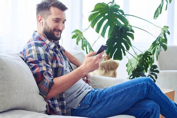 Señor deportivo escuchando música con auriculares usando smartph —  Fotos de Stock