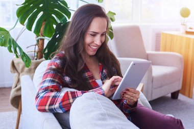 Güzel kadın kanepede otururken tablet içinde sörf