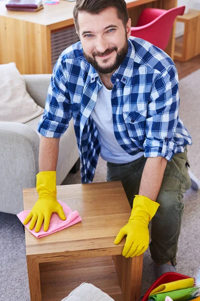 Gorgeous man in gloves mopping coffee table — Stock Photo, Image