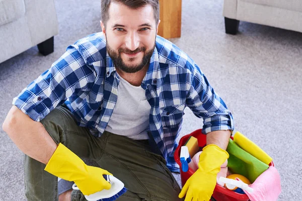 Good guy in gloves having rest while brushing carpet — Stock Photo, Image