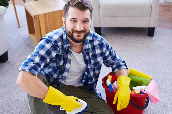 Joli monsieur dans des gants se reposer tout en brossant le tapis — Photo