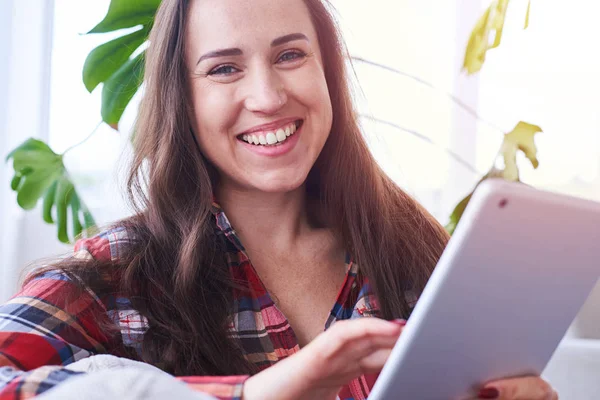 Delicioso senhora surfar em tablet enquanto sentado no sofá — Fotografia de Stock