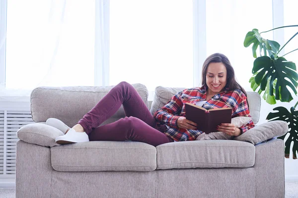 Knappe vrouw rust tijdens het lezen van boek — Stockfoto