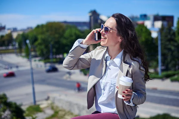 Senhora bonita falando no telefone enquanto segurando xícara de café — Fotografia de Stock