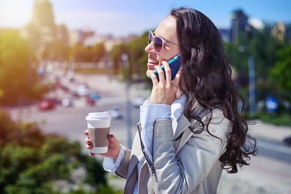 Sierlijke vrouw praten over de telefoon terwijl het drinken van koffie — Stockfoto