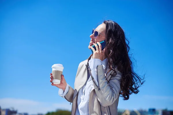コーヒーを飲みながら携帯電話で話している素晴らしい黒髪 — ストック写真