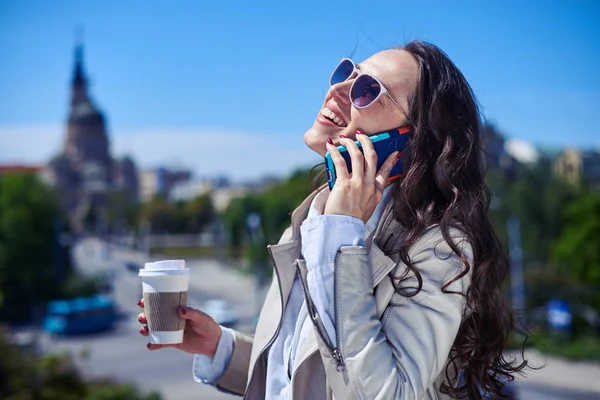 Pretty female talking on phone while drinking coffee — Stock Photo, Image