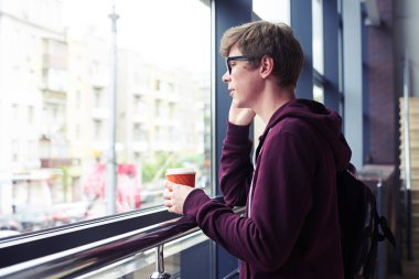 Evet ve kahve tutan gözlüklü erkek