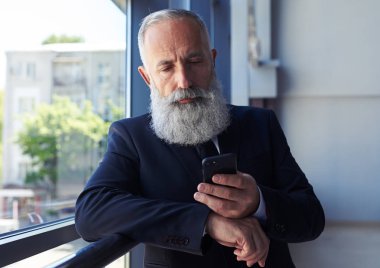 Sağlam efendim Küpeşte eğilerek Smartphone içinde sörf