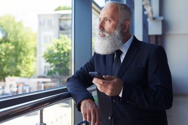 Yakışıklı beyefendi pencere mobil ph sörf yaparken bakarak