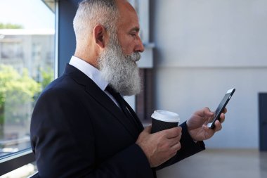 Kahve içme ve telefon sörf konsantre eski efendim