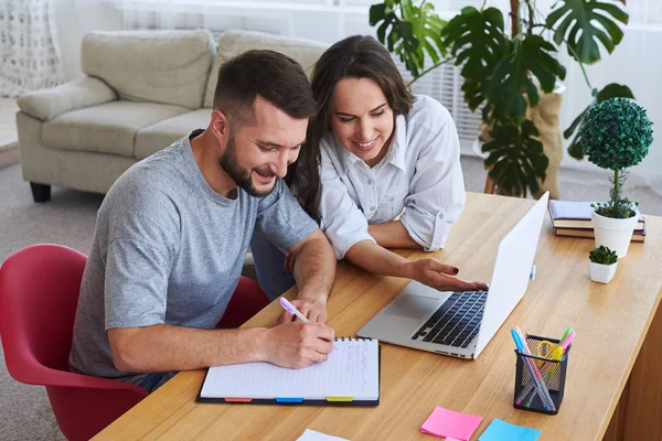 Man schrijven in laptop terwijl vrouw iets laten zien aan hem in — Stockfoto